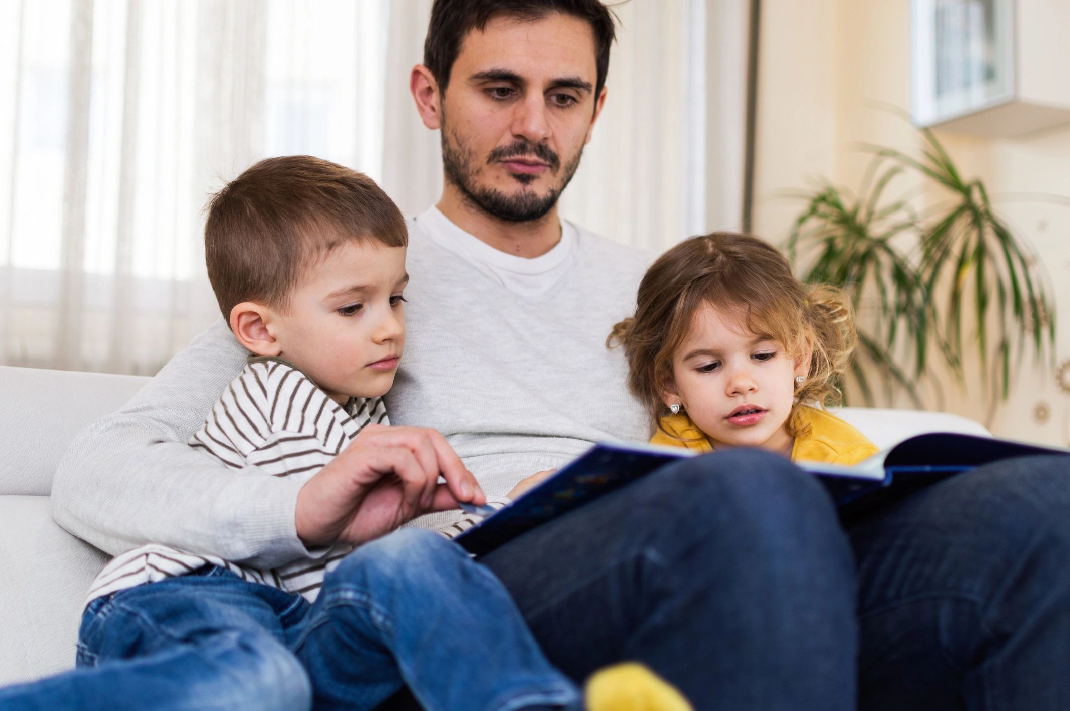 Tată citind copiilor într-un moment de familie