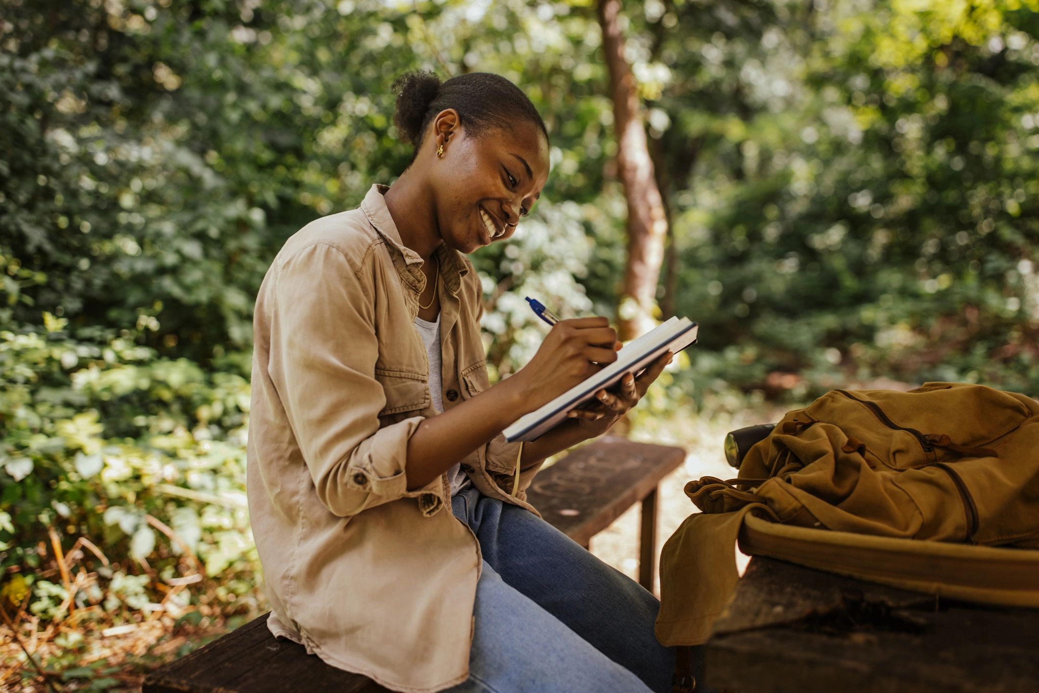 Writer journaling outdoors in a calm natural setting