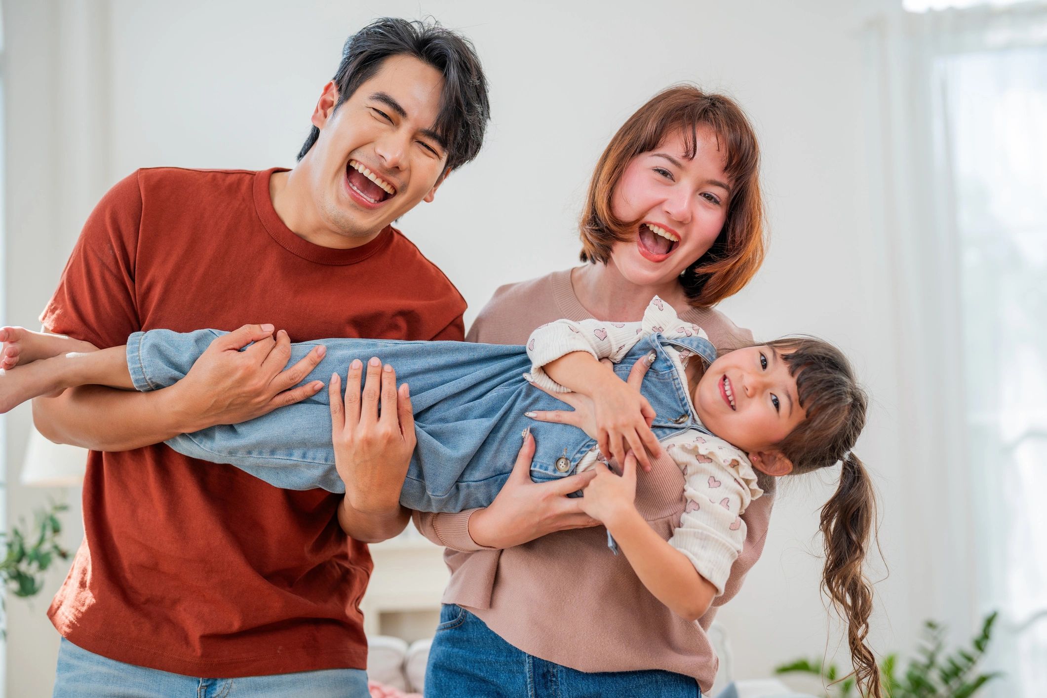Family lifting a child playfully at home
