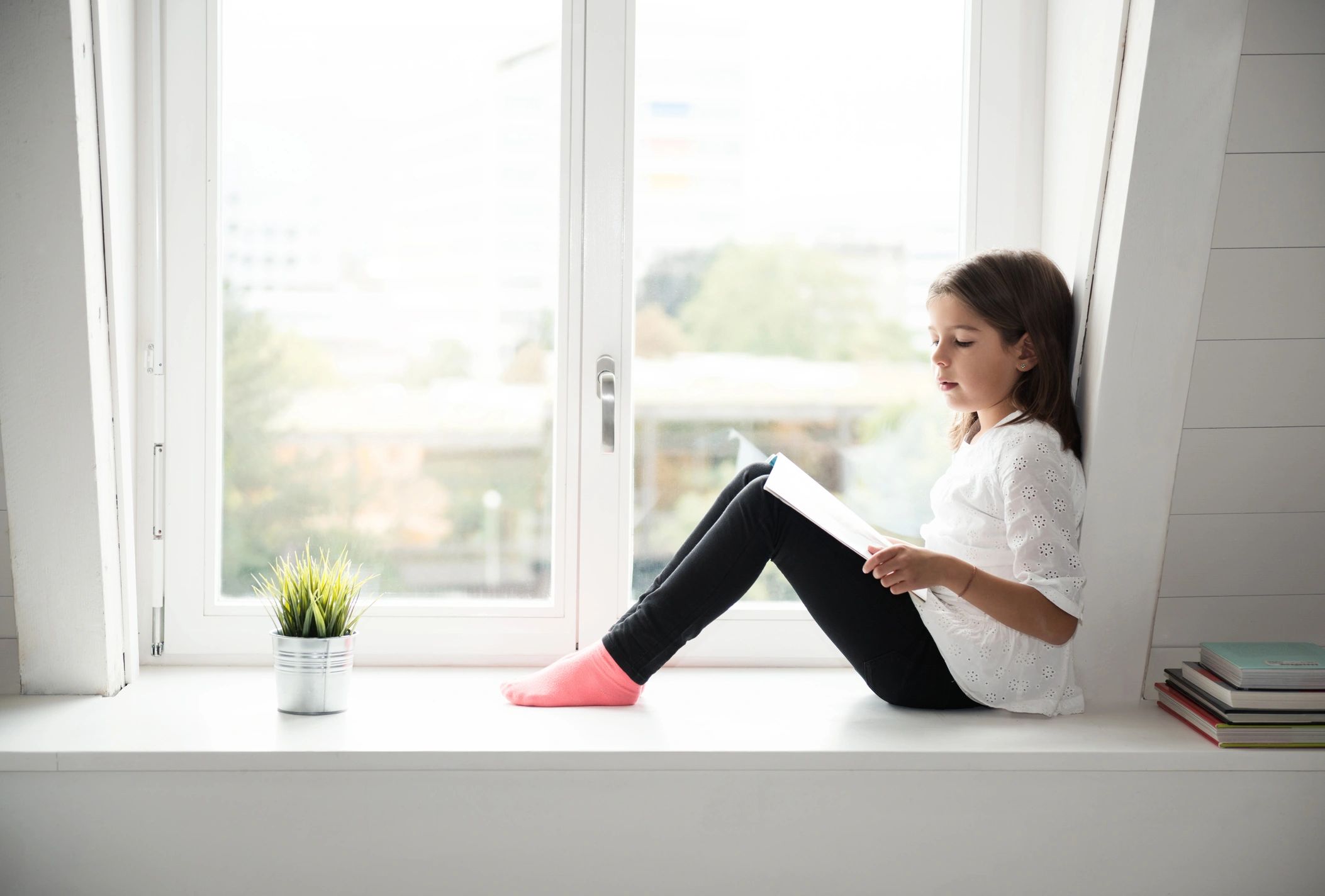 Little girl reading a children's book at home